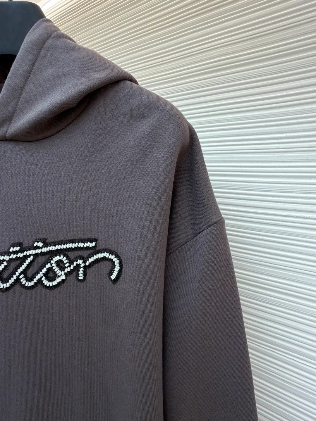 LOUIS VUITTON beaded embroidered letter hooded sweatshirt ●Original version: Purchased and developed by 13078 ●Item number: 1681742-A80 ●Fabric: pure cotton fish scale base fabric ●Technology: Pearl embroidery production ●Color: gray ●Version: fitted version ●Weight: about 805 grams ●Size: XS-S-M-L ●Description: The fabric is made of 26S double yarn + 10S fish scale bottom brushed fabric, weight 380g, with 21S double yarn 2*2 rib, weight 380g. This kind of fabric is treated with fleece to form a layer of soft and plump fluff on the inside; the improved fish scale knitting method forms a delicate concave and convex texture on the bottom surface, similar to the arrangement of fish scales. Effectively increases the air storage layer and improves thermal insulation performance. The front of the fabric is smooth and smooth, while the back is soft and waxy. It has excellent moisture absorption, breathability, wrinkle resistance and drape, and is thicker and crisper than ordinary sweatshirt materials. It gives clothes excellent warmth retention, breathability and skin-friendly touch. The Vuitton script on the chest is embroidered with beads. During the embroidery process, tiny beads are fixed on the fabric together with embroidery thread. The direct characteristics brought by this process are a strong three-dimensional sense, a unique sense of weight and a reflective effect that changes with the light. The overall wiring is straight and delicate, the fabric is comfortable and soft, and the color is consistent without color difference. It can be matched with the same style to create a fashionable look and control various occasions. Customized accessories, complete with three standards, same style for men and women!